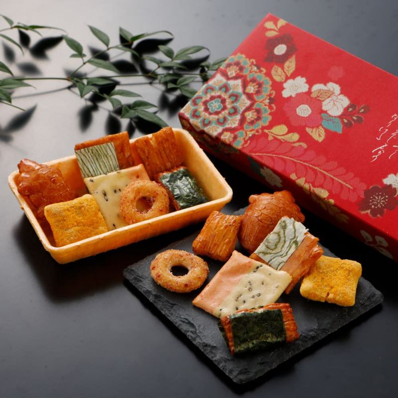 食せる海老せんべいに集めた京のあられの傑作選。京の風情を艶やかに描く紅の箱は極朱珍:紅